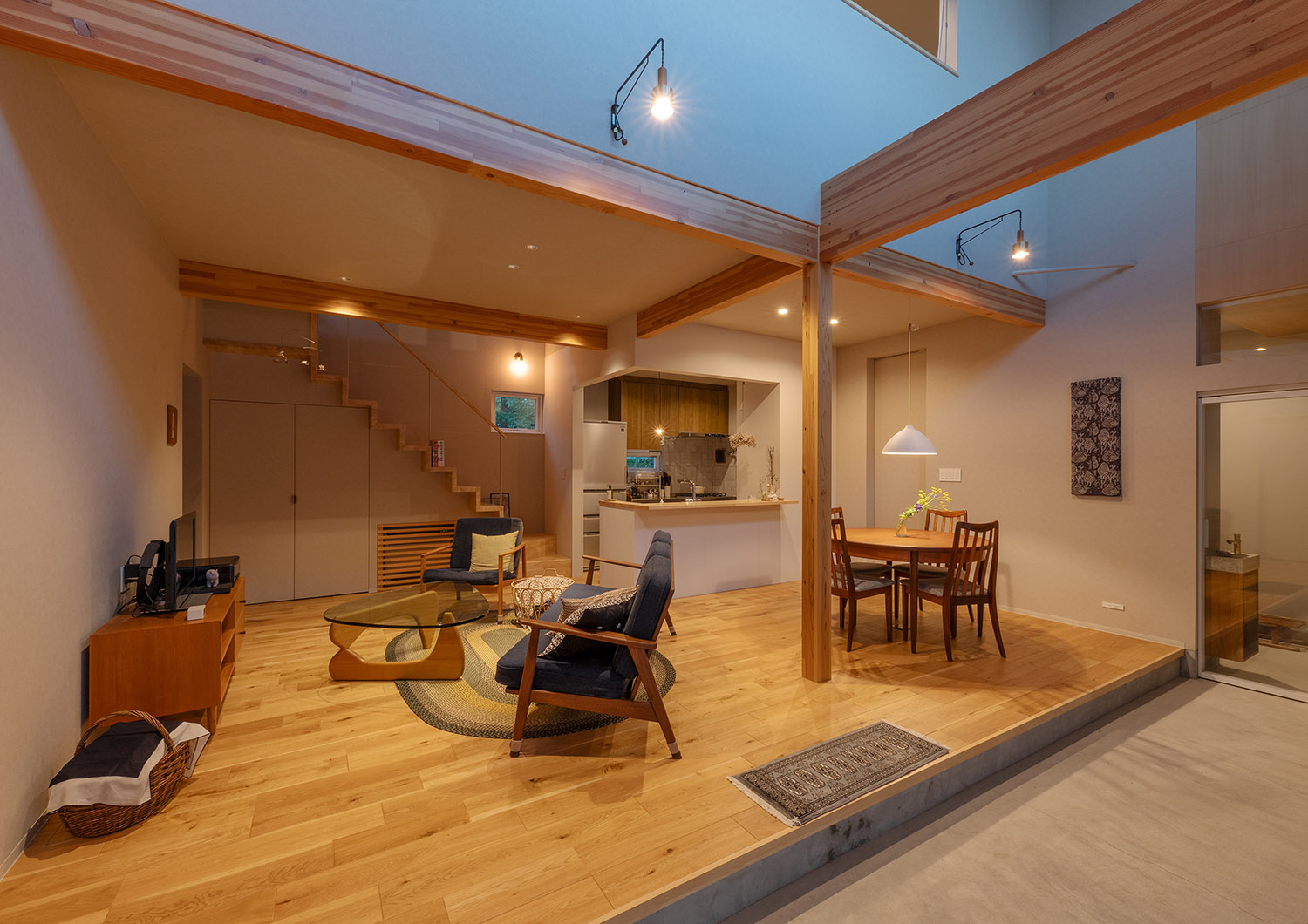 壁に間接照明が取り付けられた吹き抜けのあるLDK・デザイン住宅 注文住宅・デザイン住宅建築実例_『CASE767 ウチソトのドマ』_LDK