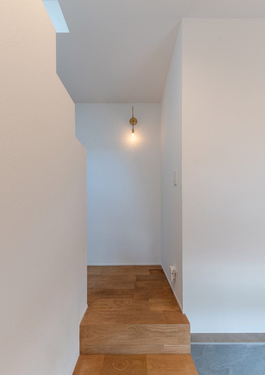 白い壁にアンティーク調のペンダントライトがある廊下・デザイン住宅 注文住宅・デザイン住宅建築実例_『CASE770 籠(こ)もれる家』_玄関