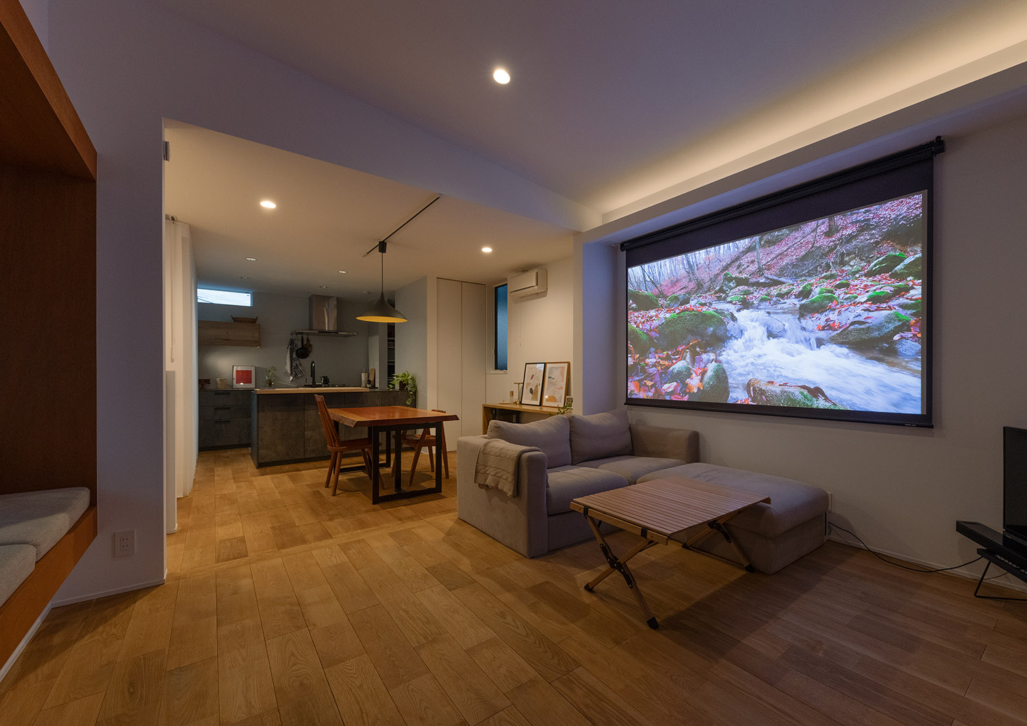 ロールスクリーンにプロジェクターの映像が映し出されたホームシアターのあるLDK・デザイン住宅 注文住宅・デザイン住宅建築実例_『CASE770 籠(こ)もれる家』_LDK