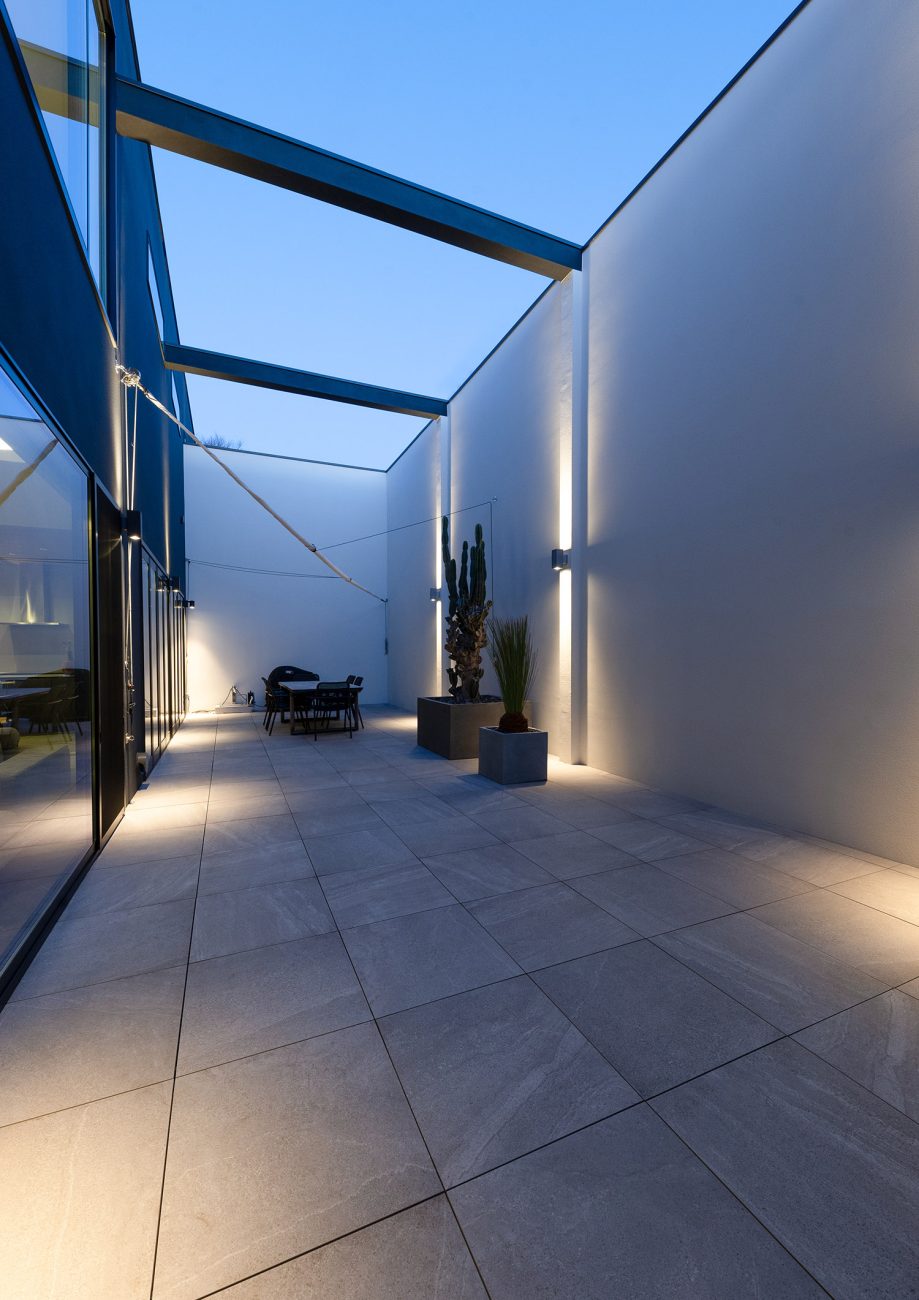 間接照明が取り付けられた高い目隠し壁のあるプライベートな中庭・デザイン住宅 注文住宅・デザイン住宅建築実例_『CASE771 VOIDS』_テラス・バルコニー