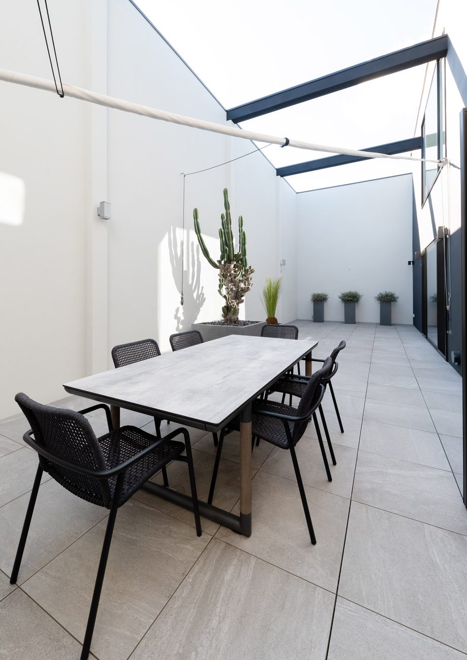 椅子とテーブルが置かれたリゾートホテルのような中庭・デザイン住宅 注文住宅・デザイン住宅建築実例_『CASE771 VOIDS』_テラス・バルコニー