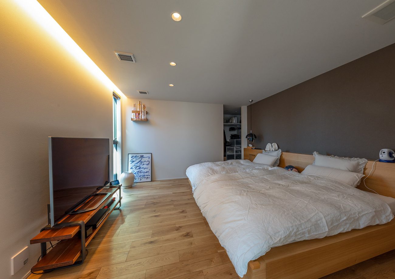 壁際に間接照明を取り付けたテレビのあるホテルライクな寝室・デザイン住宅 注文住宅・デザイン住宅建築実例_『CASE771 VOIDS』_寝室