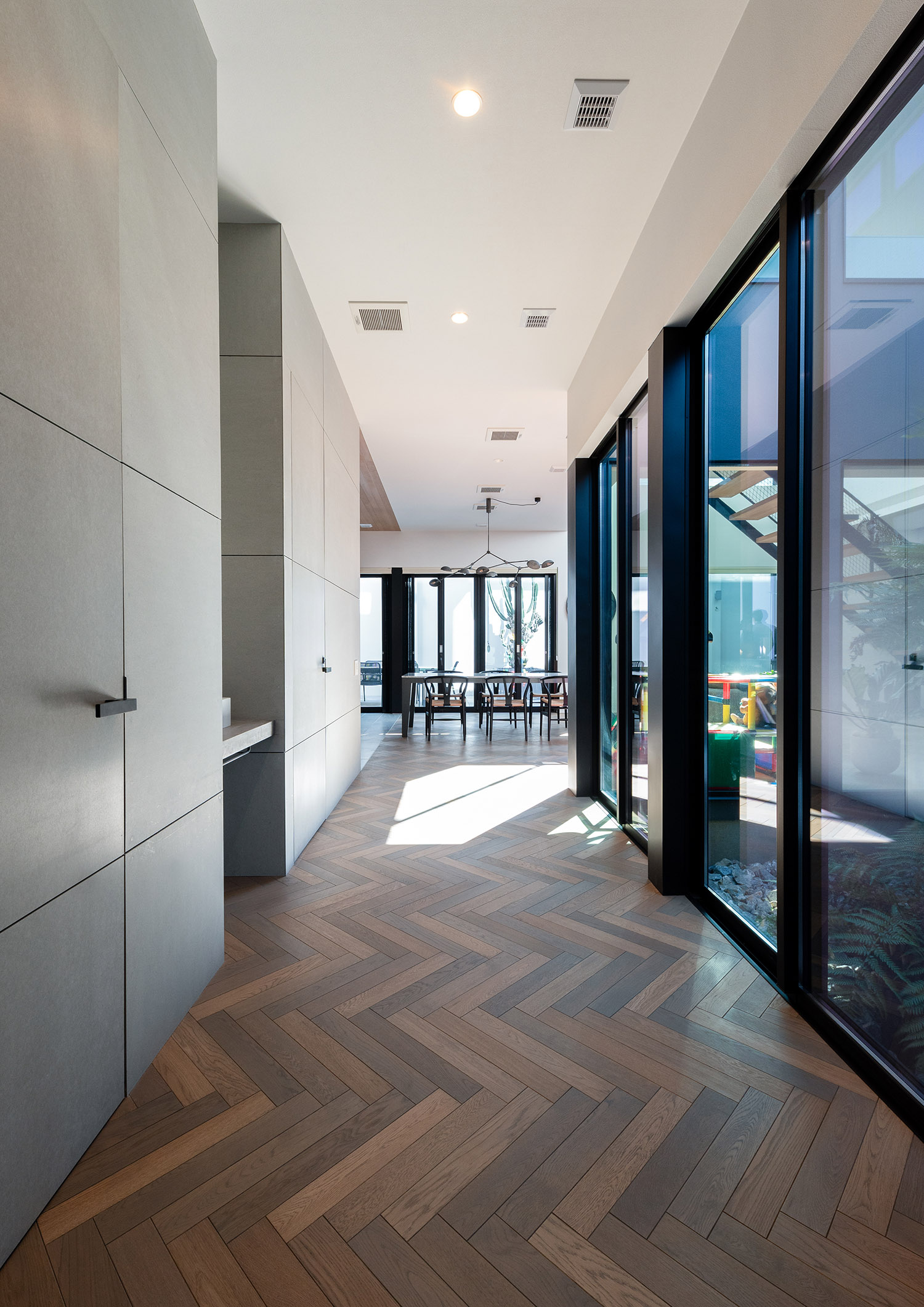 大きな窓に面したヘリンボーン床の廊下・デザイン住宅 注文住宅・デザイン住宅建築実例_『CASE771 VOIDS』_廊下