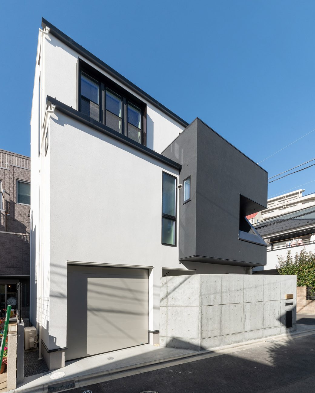 シャッター付きのインナーガレージがあるシンプルなモノトーンの外壁の家・デザイン住宅 注文住宅・デザイン住宅建築実例_『CASE769 othello』_外観