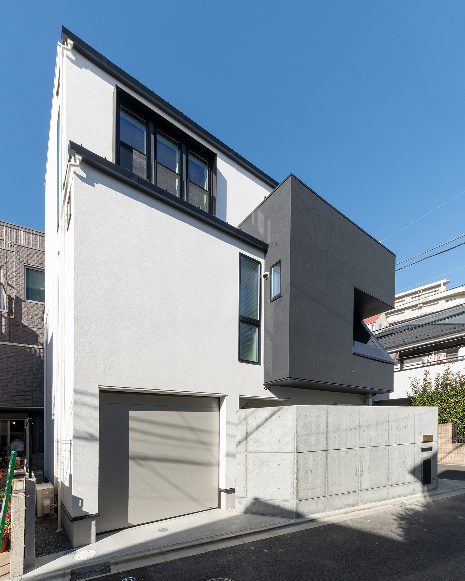 シャッター付きのインナーガレージがあるシンプルなモノトーンの外壁の家・デザイン住宅 注文住宅・デザイン住宅建築実例_『CASE769 othello』_外観