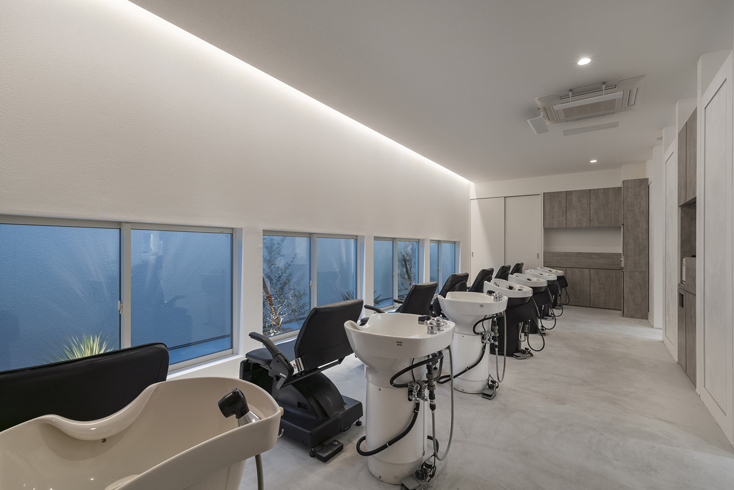 低めの位置の窓から観葉植物が目に入るシャンプー台があるヘアサロン・店舗併用住宅 注文住宅・デザイン住宅建築実例_『CASE773 hairsalon Laetitia loco』_店舗