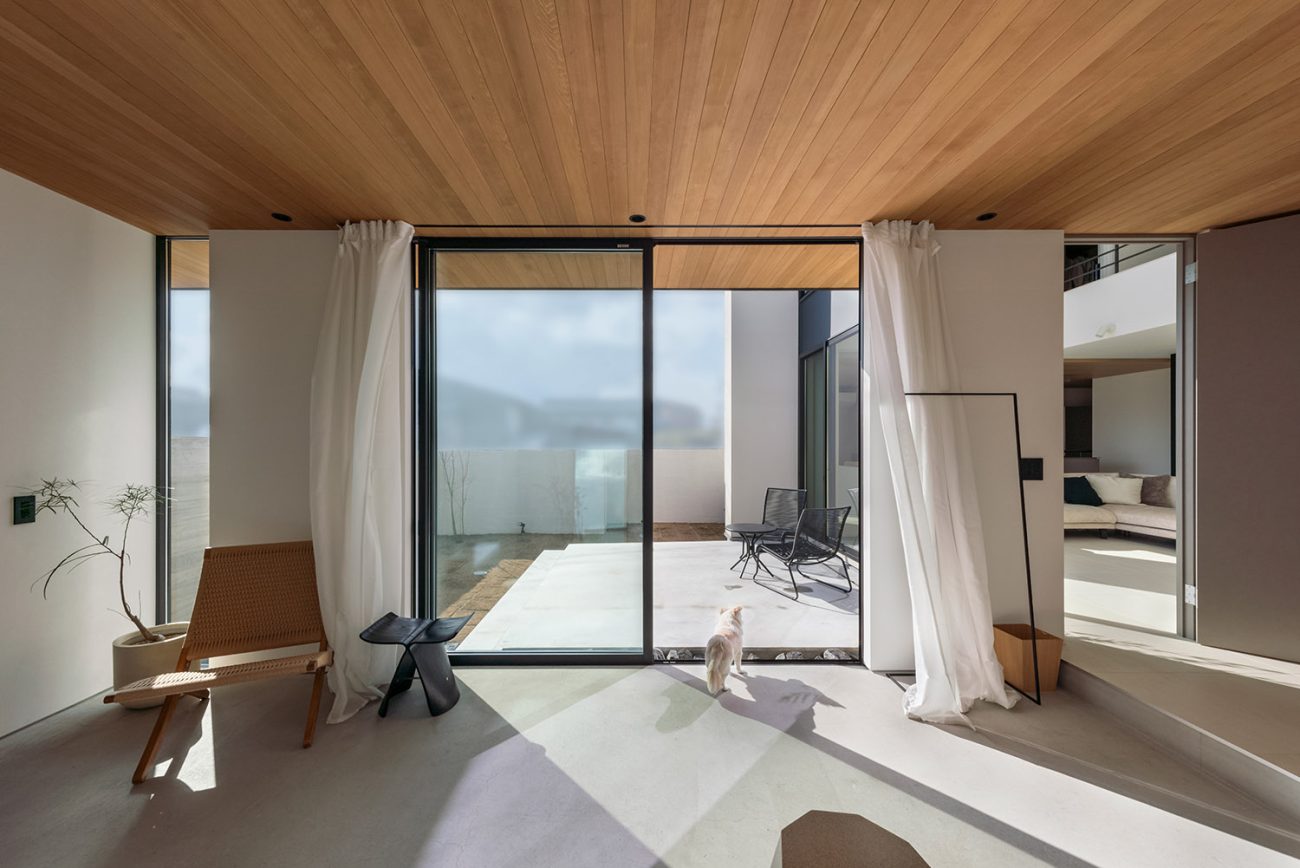 テラスに面した大きな窓がある開放的なモルタルの土間玄関・デザイン住宅 注文住宅・デザイン住宅建築実例_『CASE768 Living with light』_玄関