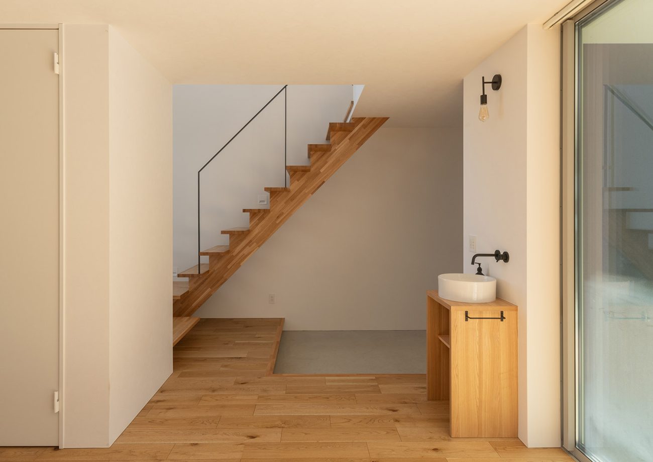 玄関を横切る木のスケルトン階段・デザイン住宅 注文住宅・デザイン住宅建築実例_『CASE775 二色の陽射し』_玄関・階段