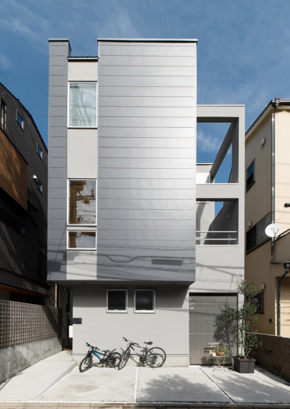 シルバーの外壁がスタイリッシュな三階建ての外観