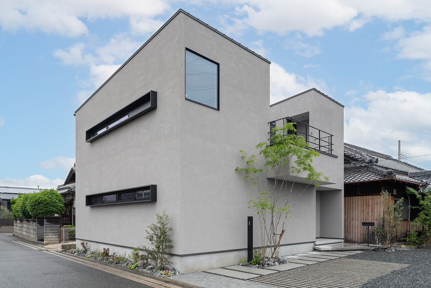 シンボルツリーやテラスのある二階建ての外観