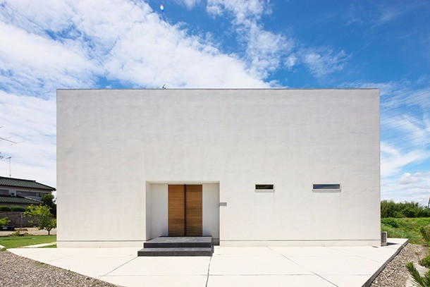 玄関ドアがアクセントになっているシンプルな四角い家