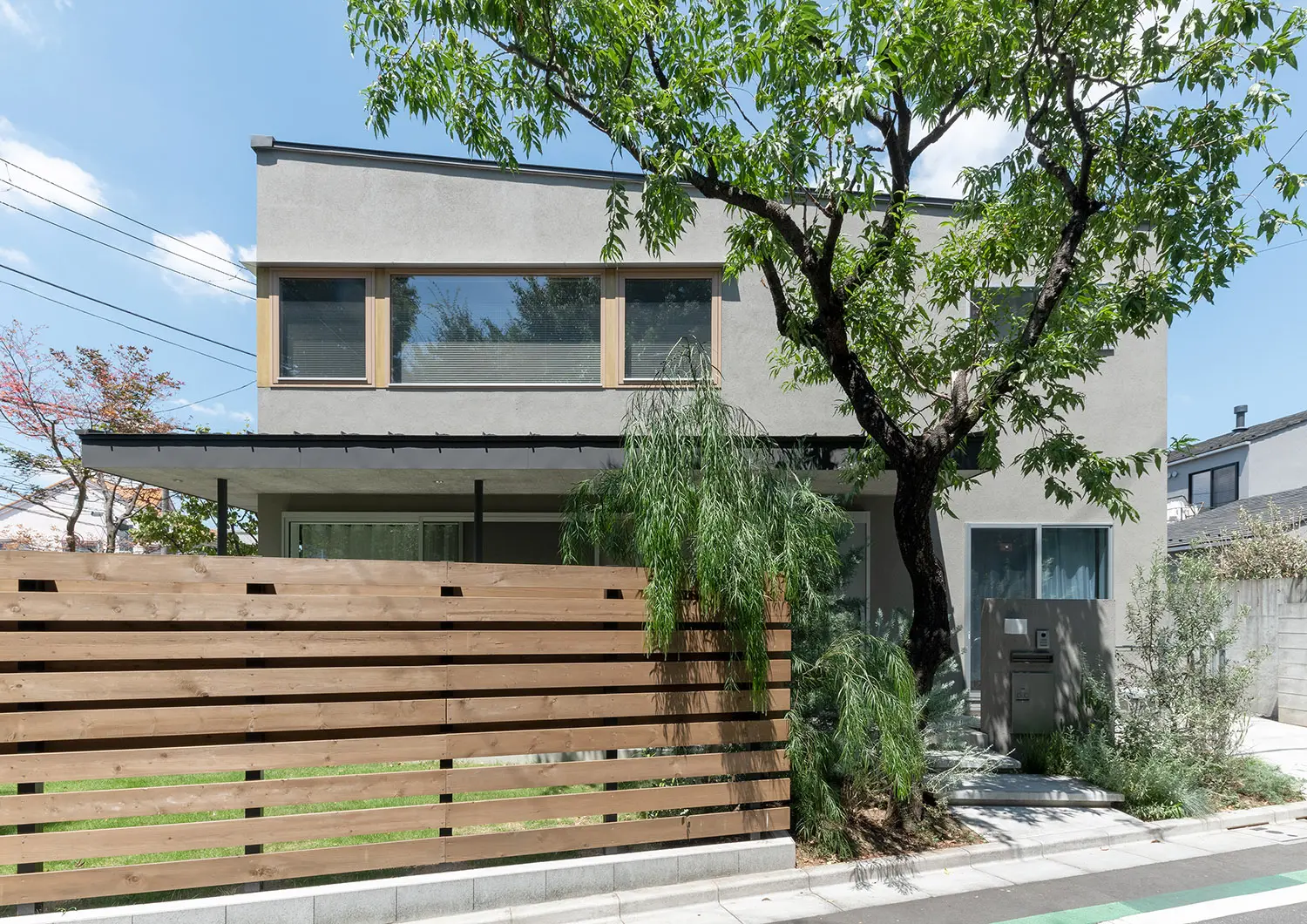 グレーの外壁や木のルーバーや特徴的な注文住宅の外観