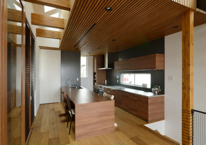 室内のインテリアにマッチした木製セパレートキッチンの実例